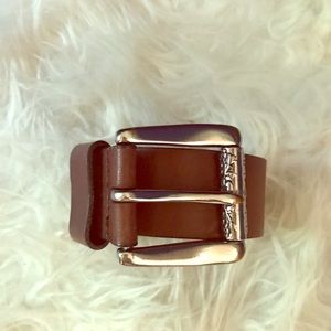 Women’s belt with floral design on buckle.